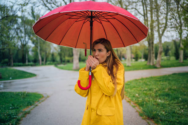 istock Woman under the umbrella warms her hands with breath 1221850676