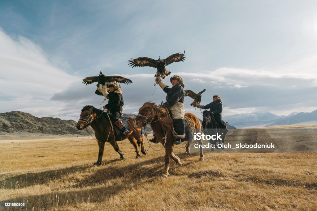 Portrait of group of eagle hunters near the river in Mongolia Portrait of group of eagle hunters in Mongolia  on the background of river Independent Mongolia Stock Photo