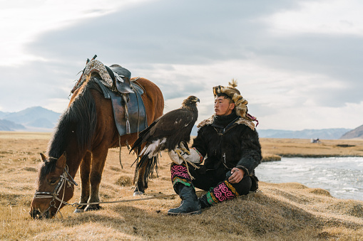 Portrait of eagle hunter  near the river  in Mongolia