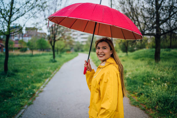 istock Joyful woman walking in rainy weather 1221851398