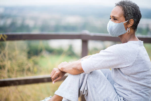 Beautiful African American Woman Senior Portrait Wearing Mask A portrait of a beautiful senior African American Woman wearing a mask behavior femininity outdoors horizontal stock pictures, royalty-free photos & images