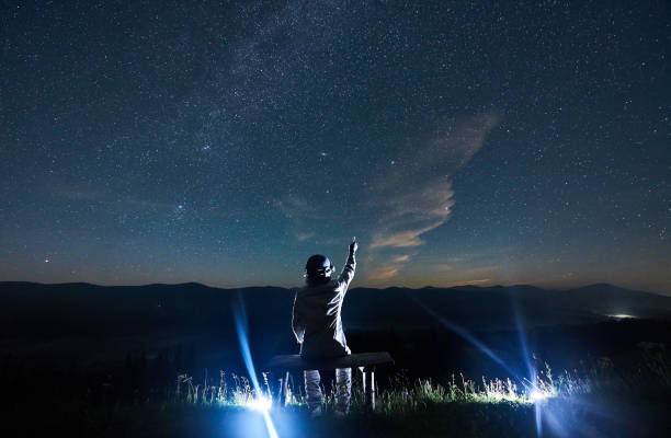 istock Space traveler pointing at beautiful night sky. 1221852171
