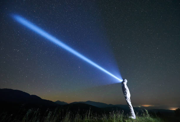 istock Space traveler shining flashlight into beautiful starry sky. 1221852174