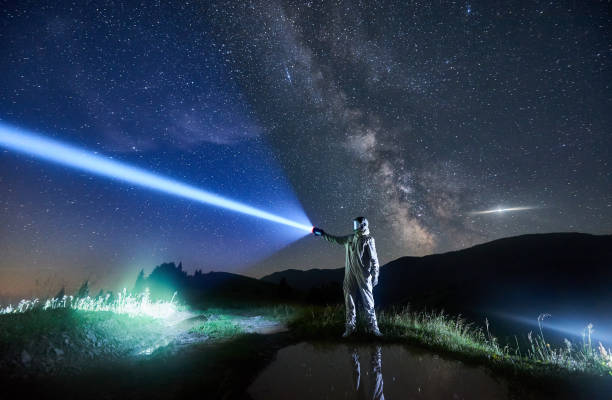istock Space traveler shining flashlight into beautiful starry sky. 1221852178