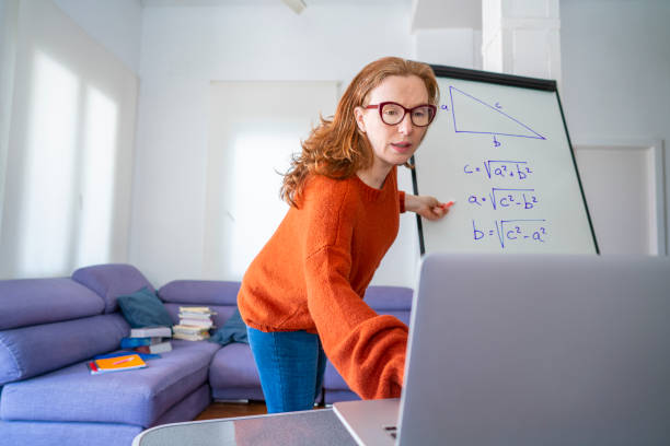 Teacher woman teaching remotely from home Maths class Teacher woman teaching remotely from home Maths class with Pitagoras triangle formula e learning photos stock pictures, royalty-free photos & images