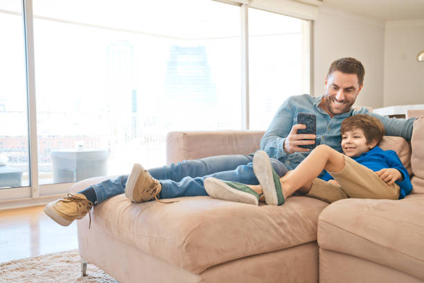 istock Father and son using smart phone during lockdown due to COVID-19 1221853743