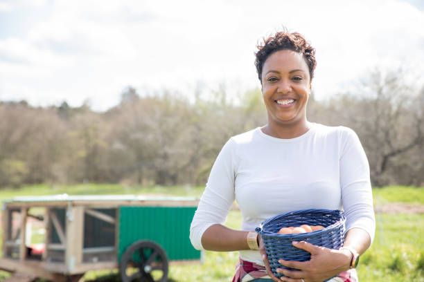 istock Woman smiles while collecting eggs on her farm 1221856229