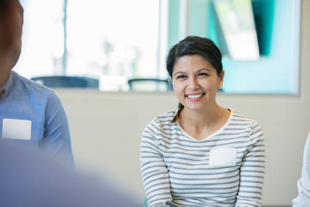 istock Professional female smiles at colleagues during a support group meeting 1221856243