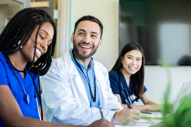 Medical students smile during meeting in conference room Medical students smile during meeting in conference room lab coat photos stock pictures, royalty-free photos & images