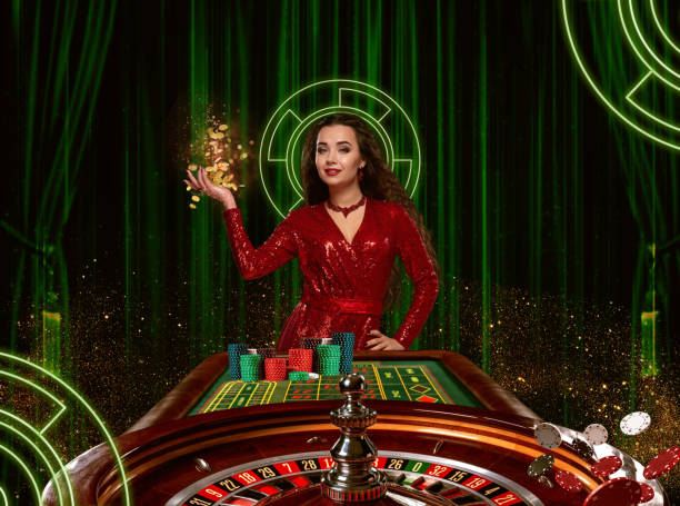 Golden coins falling down on palm of female in red dress who posing near roulette with stacks of chips. Background with green curtains. Poker, casino stock photo