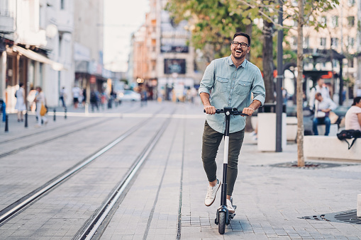 Cheerful man with an electric scooter