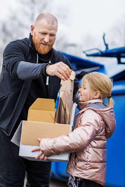 istock Father and daughter recycling paper 1221863815