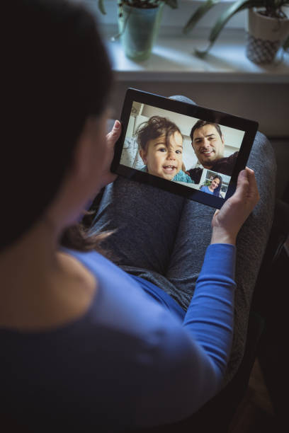Home isolated woman in a video call with her husband and baby Home isolated woman in a video call with her husband and baby. Belgrade, Serbia real wife stories stock pictures, royalty-free photos & images