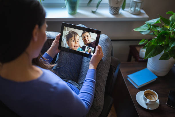 Home isolated woman in a video call with her husband and baby Home isolated woman in a video call with her husband and baby. Belgrade, Serbia real wife stories stock pictures, royalty-free photos & images