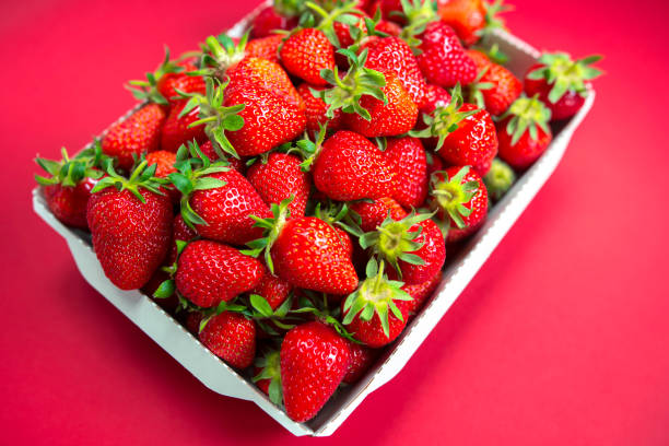 istock Bright juicy selected strawberries in a portioned cardboard box. 1221865366