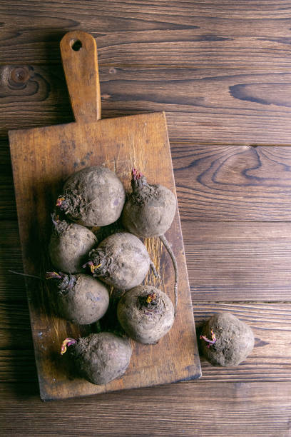 Fresh picked organic beetroot on old rustic wooden board, on wooden background