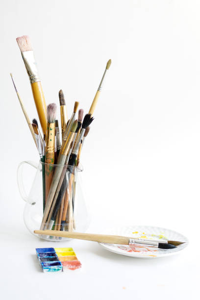 istock Many paint brushes stand in a glass jar. Paint brushes of different sizes and composition. Copy spase, white background 1221866276