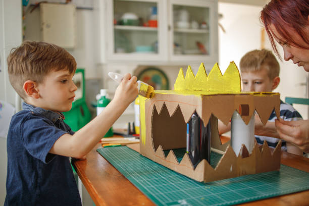 istock Brothers painting a cardboard dinosaur costume 1221866525