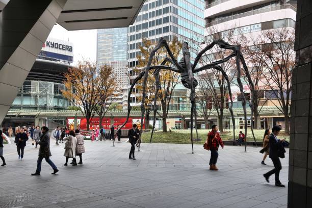 People visit Roppongi Hills spider monument in Tokyo, Japan. The Spider is a popular meeting place for local people. Maman sculpture was created in 1999 by Louise Bourgeois.