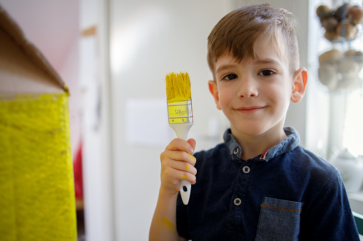 Smiling Boy holding paintbrush
