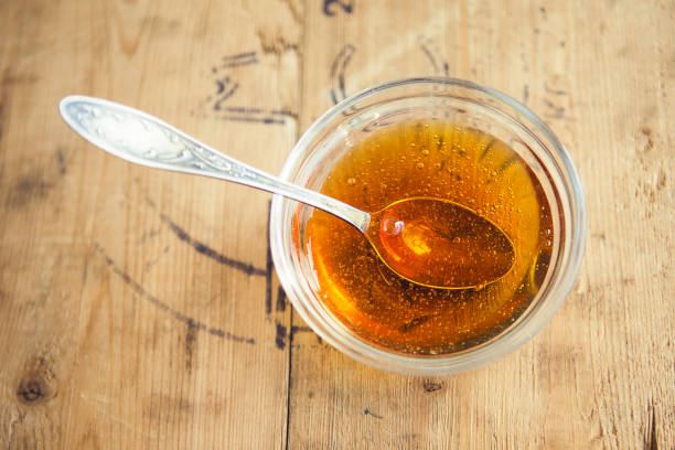 istock cup of honey with spoon on wooden table 1221869355