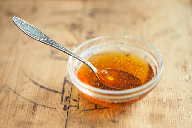 istock cup of honey with spoon on wooden table 1221869428