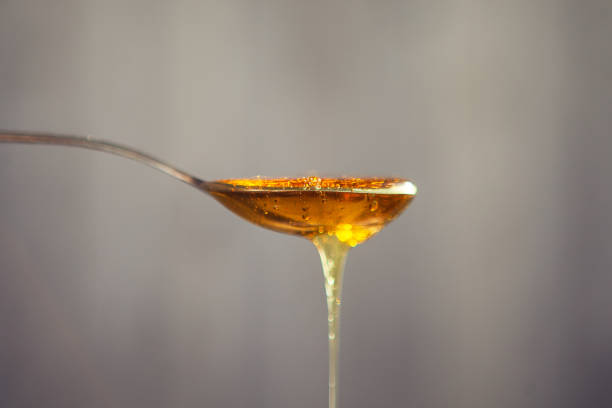 istock Honey dripping from the spoon. Golden liquid in the spoon 1221869508