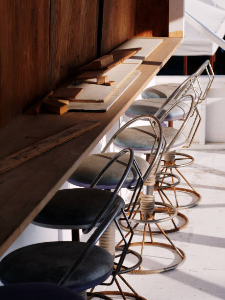 istock Weathered round bar stools with backrest and wooden table being deconstructed 1221870285