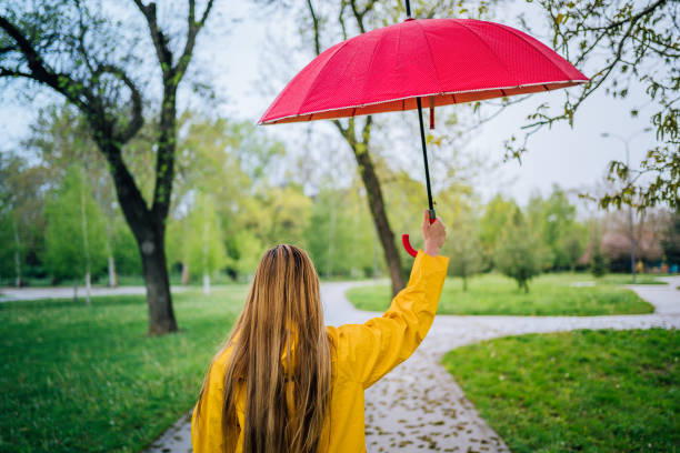 istock Woman with umbrella in the rain 1221870337