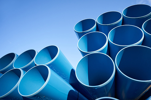 Large blue pipes for sewage against a blue sky with text space