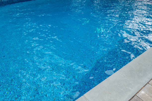 istock blue gound pool with wavy highlights and cement and brick circumference masonry 1221871227