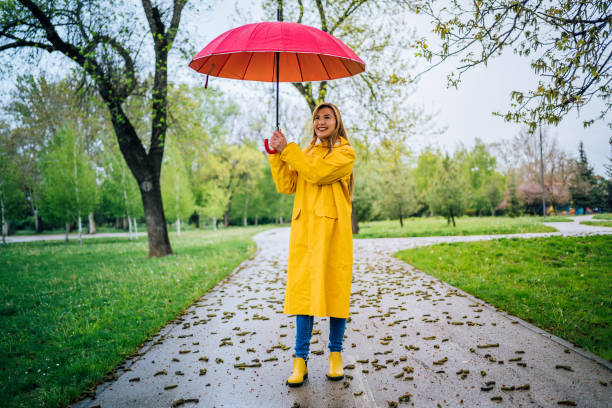 istock Woman holding a red umbrella while walking in the rain 1221871727
