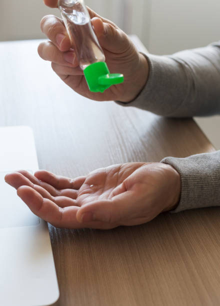 istock Man using his sanitizer for disinfection hands before his work from home office 1221876590