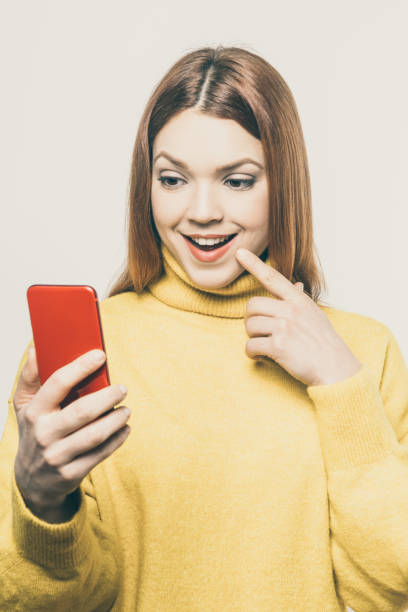 istock Smiling young woman using smartphone 1221878511
