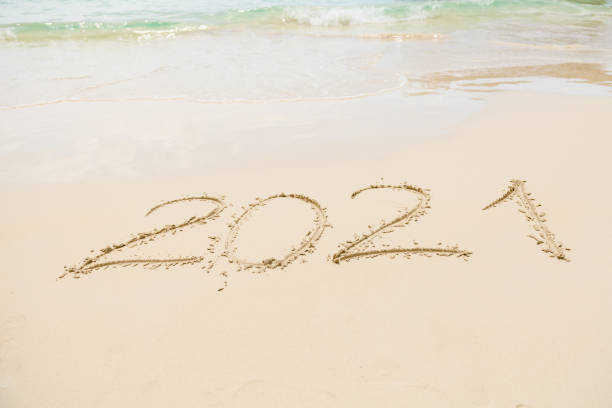 istock Number 2021 and footprints at sand sea beach 1221879490