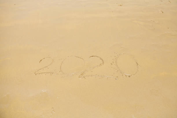 istock Sand with hand writing 2020 year close up 1221879492