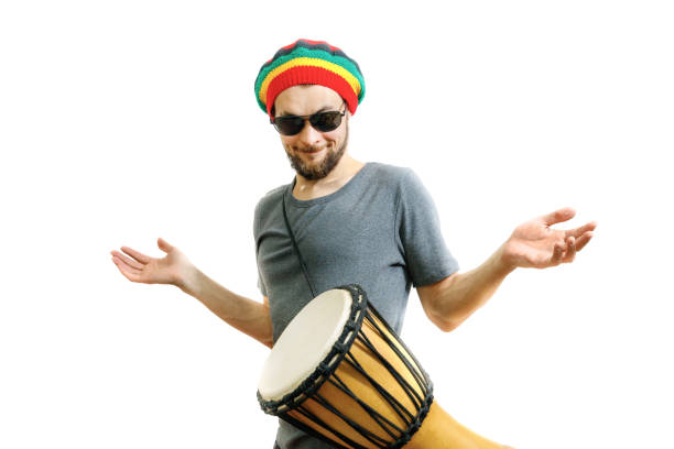 istock Young handsome guy learns to play the djembe drum instrument on a white background 1221880147