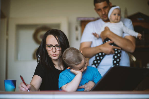 istock Working mom using laptop as husband cares for baby 1221880148