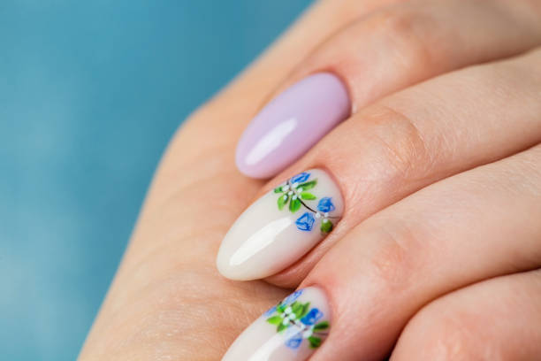 istock Nails Design. Hands With Bright lilac and White Manicure with Spring flowers. Close Up Of Female Hands. Art Nail. 1221880889