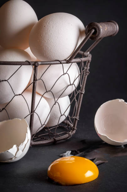 istock Eggs in a basket and a cracked egg close-up. 1221881820