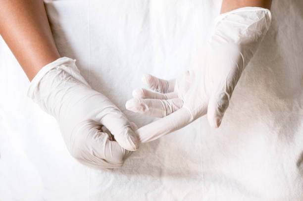 istock covid-19 - Putting on gloves 1221881858