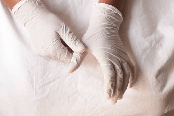 istock covid-19 - Putting on gloves 1221881888