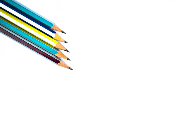 Five different colored wood pencil crayons arranged on a white paper background