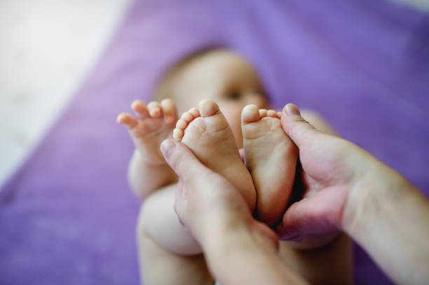 Hand with newborn baby's foot stock photo