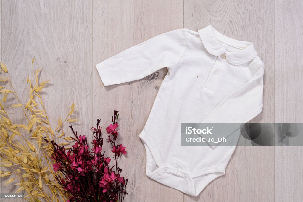 concepto de ropa de bebé. traje blanco para niño y niña sobre fondo de madera - Foto de stock de A la moda libre de derechos