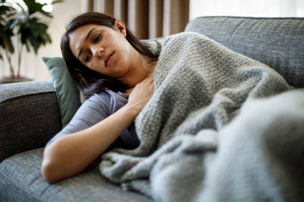 mujer enferma acostada en la cama - fragilidad fotografías e imágenes de stock