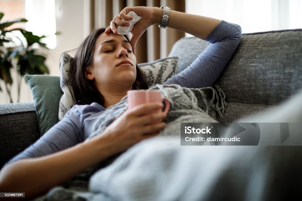 Sick woman lying in bed Cold And Flu Stock Photo