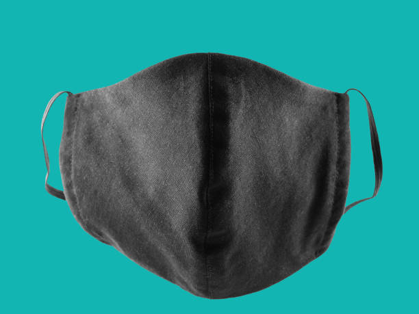 istock Protective mask pop art. Antivirus mask made from cotton. Black stylish face mask during a pandemic virus COVID-19. Face protective mask on a aquamarine background 1221888345