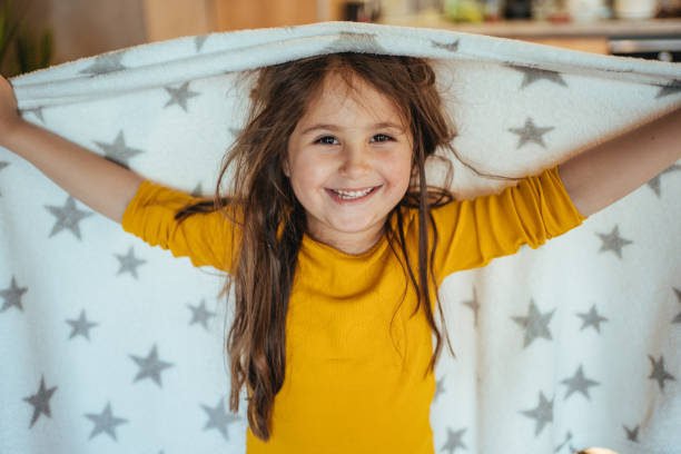 istock Charming girl playing around the house with her blanket 1221888554