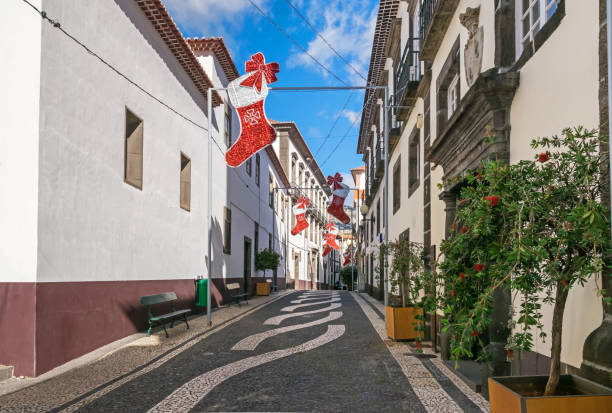 One of the narrow streets with Christmas decoration and typical Portuguese pavement in Funchal, Madeira Funchal, Portugal -  November 10, 2019: Historic centre and one of the narrow streets with Christmas decoration and typical Portuguese pavement with distinctive tiled pattern funchal christmas stock pictures, royalty-free photos & images